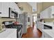 Galley kitchen with stainless steel appliances and hardwood floors at 1460 Chamblee Gap Rd, Cumming, GA 30040