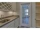 Bar area with sink, wine rack and glass door leading to another room at 5860 Collier Bridge Ln, Hoschton, GA 30548