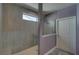Modern bathroom featuring tile shower, bench, small window and walk-in closet at 5860 Collier Bridge Ln, Hoschton, GA 30548