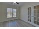 Comfortable bedroom features stylish flooring, natural light, and elegant glass paneled doors at 5860 Collier Bridge Ln, Hoschton, GA 30548