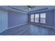 Bedroom with hardwood floors, ceiling fan, tray ceiling, and bright windows at 5860 Collier Bridge Ln, Hoschton, GA 30548