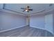 Bedroom with hardwood floors, ceiling fan, tray ceiling, and bright windows at 5860 Collier Bridge Ln, Hoschton, GA 30548