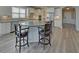 Modern kitchen with white cabinets, stainless appliances, large island and seating at 5860 Collier Bridge Ln, Hoschton, GA 30548