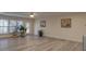 Bright living room with light wood floors, neutral walls, ceiling fan, and natural light from multiple windows at 5860 Collier Bridge Ln, Hoschton, GA 30548