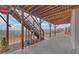 Outdoor patio space with wooden support system, cement flooring, stairs to wooded backyard, and views at 5860 Collier Bridge Ln, Hoschton, GA 30548