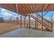 Outdoor patio with a wooden support system, stone flooring, and stairs to the wooded backyard at 5860 Collier Bridge Ln, Hoschton, GA 30548