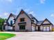 Two-story home with gray brick and white siding, featuring a three-car garage at 1095 Lanier Pl, Cumming, GA 30041