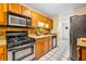 Galley kitchen with wood cabinets, stainless steel appliances, and tile floor at 5392 Brickleberry Way, Douglasville, GA 30134