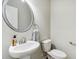 Simple bathroom with pedestal sink, toilet and large mirror at 253 N Gwinnett St, Buford, GA 30518