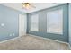 Blue bedroom with window, ceiling fan, and door at 253 N Gwinnett St, Buford, GA 30518