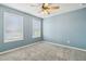 Blue bedroom with two windows and ceiling fan at 253 N Gwinnett St, Buford, GA 30518