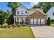 Two-story house with brick and white exterior, landscaping, and driveway at 253 N Gwinnett St, Buford, GA 30518