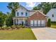 Two-story home with gray and brick exterior, attached garage, and landscaped yard at 253 N Gwinnett St, Buford, GA 30518