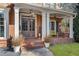 Inviting front porch with brick flooring and a yellow bench at 5507 Ashleigh Walk Nw Dr, Suwanee, GA 30024