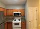 Well-equipped kitchen with wood cabinets, granite countertops, and white appliances at 4461 Ravenwood Dr, Union City, GA 30291