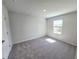 Cozy bedroom featuring neutral carpet, white walls, and a bright window with neighborhood views at 2422 Brown Dove Way Lot 70, Grayson, GA 30017