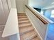 Carpeted stairs with wood railing and white banister lead to upper level at 2422 Brown Dove Way Lot 70, Grayson, GA 30017