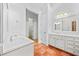 Bathroom with double vanity, marble flooring, and white cabinets at 7570 Weston Club Dr, Suwanee, GA 30024