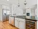 Kitchen island with granite countertop, sink, wine cooler, and stainless steel dishwasher at 7570 Weston Club Dr, Suwanee, GA 30024