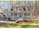 Two story house with wraparound porch, gray siding, and landscaping at 3820 Mink Livsey Rd, Snellville, GA 30039