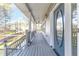 Long front porch with gray siding, teal front door, and access to stairs at 3820 Mink Livsey Rd, Snellville, GA 30039