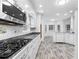 Kitchen with white cabinets, gas stove, and gray wood-look flooring at 3820 Mink Livsey Rd, Snellville, GA 30039