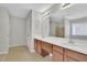 Double vanity bathroom with wood cabinets, a large mirror, and neutral colors at 381 Paper Woods Dr, Lawrenceville, GA 30046
