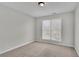 Well-lit bedroom with neutral walls, carpet flooring, and a large window at 381 Paper Woods Dr, Lawrenceville, GA 30046