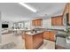 Open kitchen with island, wood cabinets, and tile flooring at 381 Paper Woods Dr, Lawrenceville, GA 30046