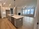 Modern kitchen with island, stainless steel appliances, and hardwood floors at 7125 Winderlea Ln, Cumming, GA 30040