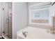 Bathroom with a soaking tub and shower, white cabinets, and neutral walls offer a modern look at 173 Mill Creek Dr, Canton, GA 30115