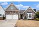 Brick home with two-car garage and landscaping at 173 Mill Creek Dr, Canton, GA 30115