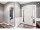 Bright foyer with elegant wainscoting, a stylish front door, and hardwood floors at 173 Mill Creek Dr, Canton, GA 30115