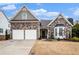 Charming stone-accented home featuring a two-car garage and inviting front porch, perfect for suburban living at 173 Mill Creek Dr, Canton, GA 30115
