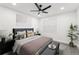 This bedroom features a ceiling fan, a large window and a queen size bed with stylish pillows and decorative art at 1288 Almont Sw Dr, Atlanta, GA 30310