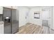 Bright area featuring stainless steel fridge, white cabinets, light wood floors, and a door at 1288 Almont Sw Dr, Atlanta, GA 30310