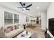 Bright living room featuring a ceiling fan, many windows, and an open floor plan to the dining area and modern kitchen at 1288 Almont Sw Dr, Atlanta, GA 30310
