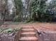 Wooded backyard with stone steps leading to a secluded area at 2669 Blount St, Atlanta, GA 30344