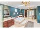 A luxurious bathroom features a jacuzzi tub, vanity, and elegant fixtures, illuminated by a skylight and chandelier at 837 Pine Ridge Dr, Lawrenceville, GA 30043