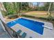 A private backyard swimming pool, surrounded by a patio with lounge chairs and green foliage at 837 Pine Ridge Dr, Lawrenceville, GA 30043