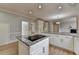 A kitchen island featuring granite countertops, a cooktop, and white cabinets at 340 Kincardine Way, Alpharetta, GA 30022