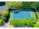 A bird's eye view of a fenced tennis court surrounded by trees, providing a private and scenic recreational space at 340 Kincardine Way, Alpharetta, GA 30022