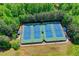 An aerial shot of well-lit, well-maintained tennis courts surrounded by trees, promoting an active and healthy lifestyle at 340 Kincardine Way, Alpharetta, GA 30022