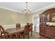 Elegant dining room with a large wooden table, chandelier, and built-in hutch at 255 Thornbush Ln, Lawrenceville, GA 30046