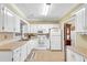 Galley kitchen with white cabinets, tile flooring, and stainless steel appliances at 255 Thornbush Ln, Lawrenceville, GA 30046