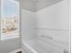 Bright white bathtub with shower and window view at 2295 Creekview Trl, Decatur, GA 30035