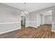 The formal dining room has an updated light fixture, wood floors, and a view to the kitchen at 2295 Creekview Trl, Decatur, GA 30035