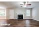 Open-concept living room featuring dark wood floors, a fireplace, and a ceiling fan at 2295 Creekview Trl, Decatur, GA 30035