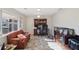 Bright living room featuring large windows, a leather couch, and a wooden desk with storage at 7034 Capps Ferry Rd, Douglasville, GA 30135