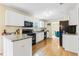 Well-lit kitchen featuring granite countertops, white cabinets and stainless appliances with view to dining at 6834 Fireside Ln, South Fulton, GA 30349